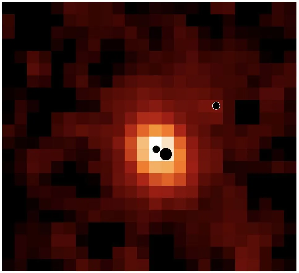 Pixelated map in red and orange with a bright central area and three black circles, two at the centre and one to the right