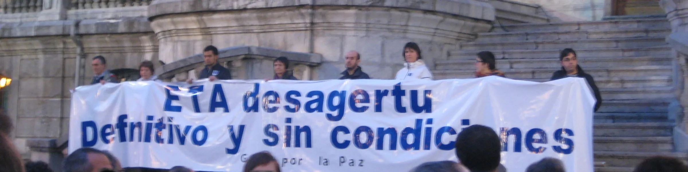 A white Gesto por la Paz banner on the steps of Bilbao City Hall reading "ETA desagertu. Definitivo y sin condiciones"