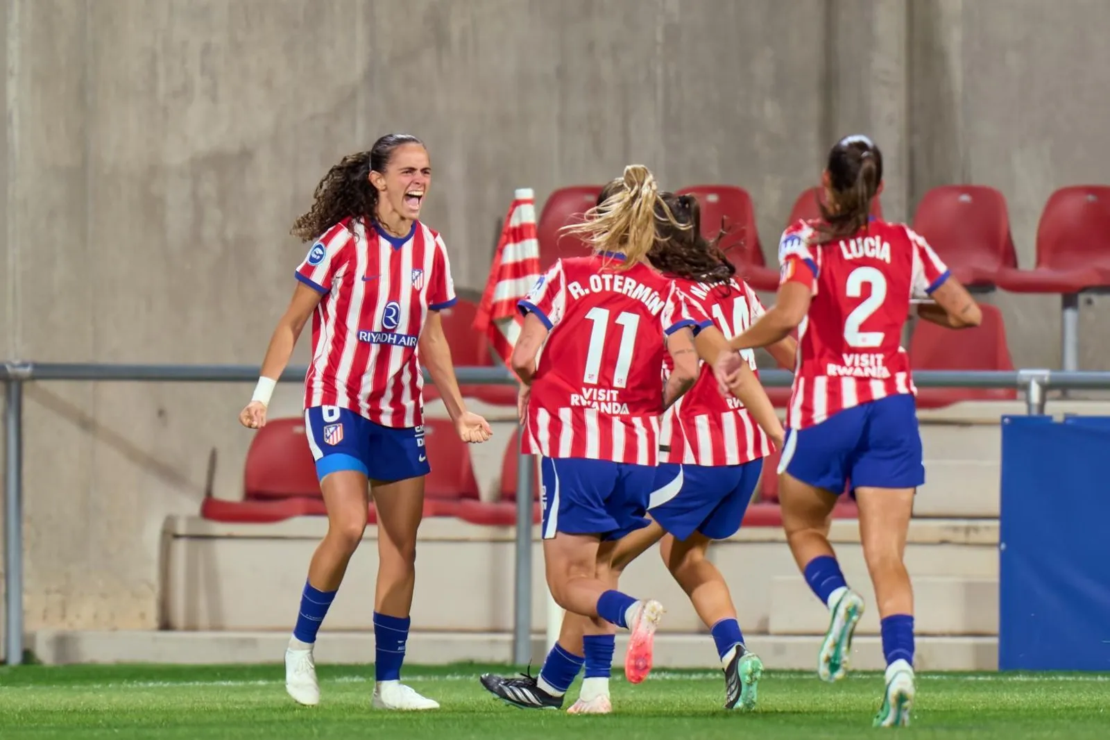 Atlético de Madrid players in red-and-white striped shirts celebrate on the pitch during a match