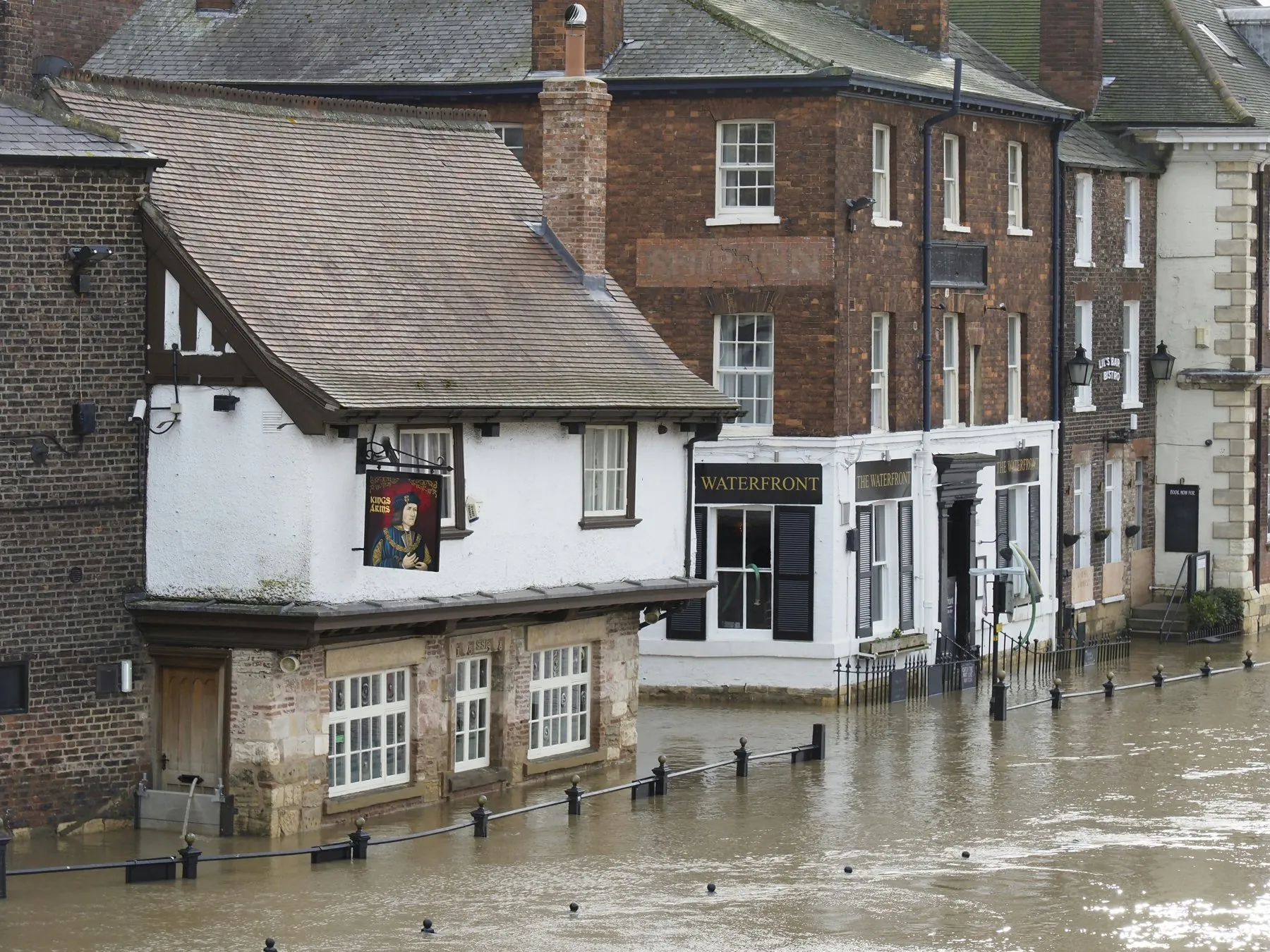 A riverside street in York, England, flooded up to the ground-floor windows of an old pub and brick buildings